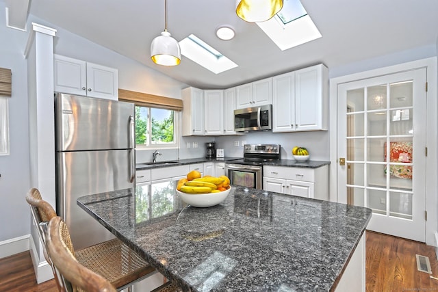 23 Briarwood Dr, Old Saybrook, CT 06475 - kitchen with appliances with stainless steel finishes, a skylight, dark wood finished floors, white cabinets, and vaulted ceiling