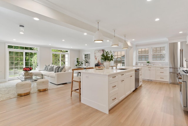 36 Hendrie Ave, Greenwich, CT 06878 - kitchen featuring stainless steel appliances, light wood-type flooring, crown molding, white cabinetry, and open floor plan