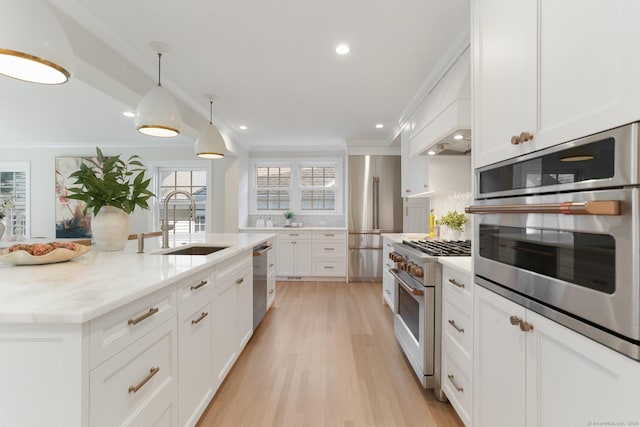 36 Hendrie Ave, Greenwich, CT 06878 - kitchen featuring premium appliances, white cabinetry, ornamental molding, light wood-style floors, and light stone counters