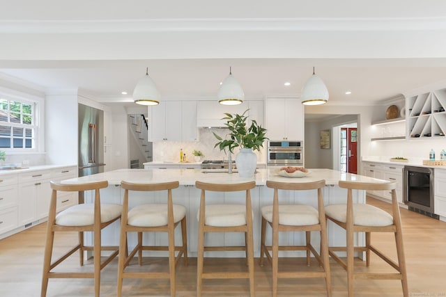 36 Hendrie Ave, Greenwich, CT 06878 - kitchen featuring stainless steel appliances, light countertops, open shelves, ornamental molding, and a center island with sink