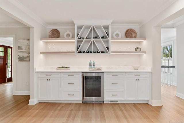 36 Hendrie Ave, Greenwich, CT 06878 - indoor wet bar featuring beverage cooler, light wood-type flooring, and crown molding