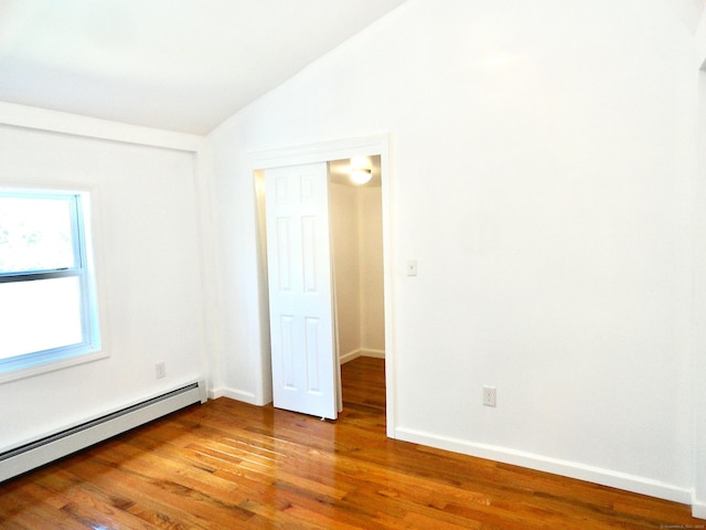 23 Norfolk Rd, Torrington, CT 06790 - unfurnished room featuring a baseboard heating unit, vaulted ceiling, and wood finished floors