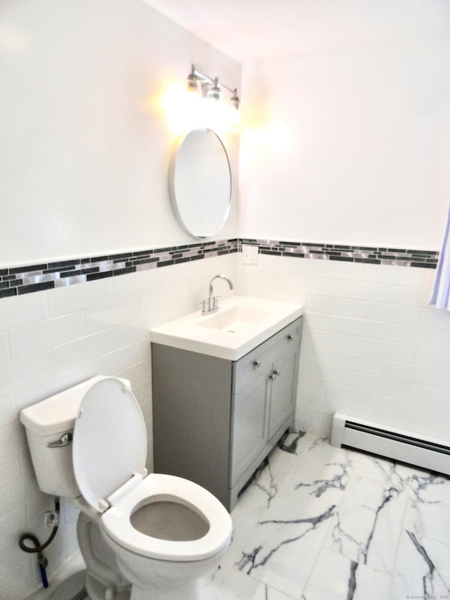 23 Norfolk Rd, Torrington, CT 06790 - half bathroom with a baseboard radiator, tile walls, vanity, a wainscoted wall, and marble look tiles