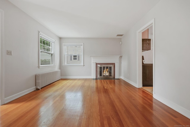 22 Brundage St, Stamford, CT 06907 - unfurnished living room with radiator, wood finished floors, and a fireplace