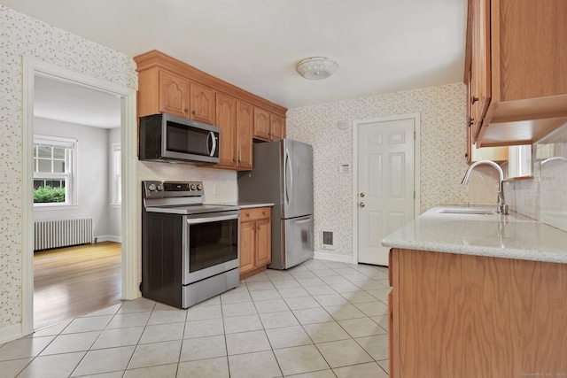 22 Brundage St, Stamford, CT 06907 - kitchen featuring stainless steel appliances, radiator, wallpapered walls, light stone countertops, and light tile patterned flooring