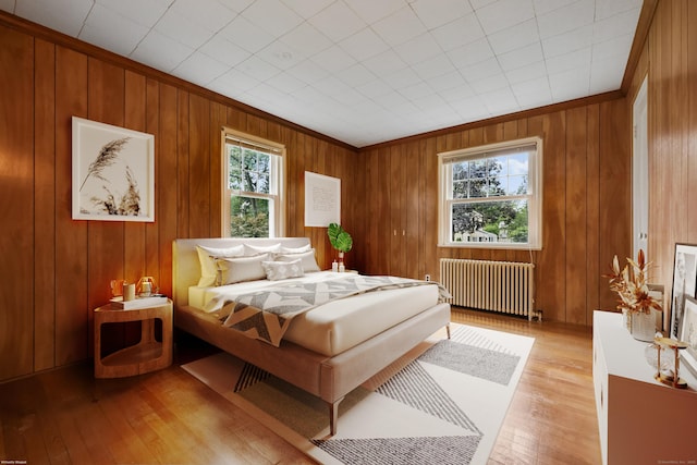22 Brundage St, Stamford, CT 06907 - bedroom with radiator heating unit, light wood-style flooring, and wooden walls