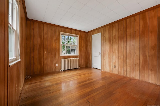 22 Brundage St, Stamford, CT 06907 - empty room with radiator heating unit, wood-type flooring, and wood walls