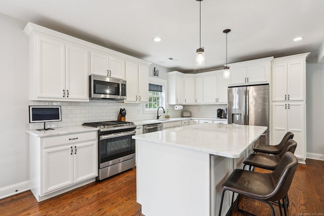 15 Wondy Way, Danbury, CT 06811 - kitchen with appliances with stainless steel finishes, dark wood-type flooring, a center island, a breakfast bar, and backsplash