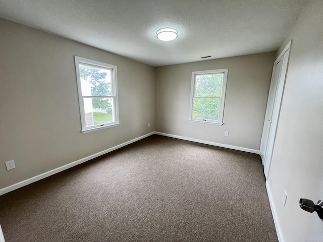 212 Clement Rd, East Hartford, CT 06118 - empty room with dark colored carpet and a textured ceiling