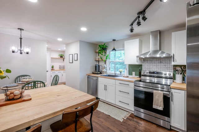81 Burwell Rd, New Hartford, CT 06057 - kitchen featuring appliances with stainless steel finishes, wall chimney exhaust hood, wooden counters, dark wood finished floors, and hanging light fixtures