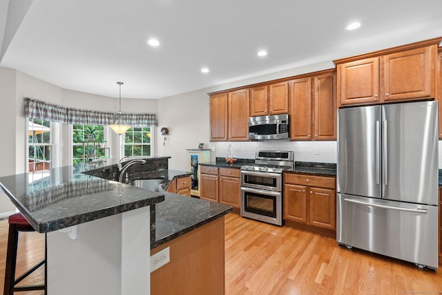 25 Quarry Ln Unit 25, Berlin, CT 06037 - kitchen with stainless steel appliances, light wood-style flooring, brown cabinets, decorative backsplash, and recessed lighting