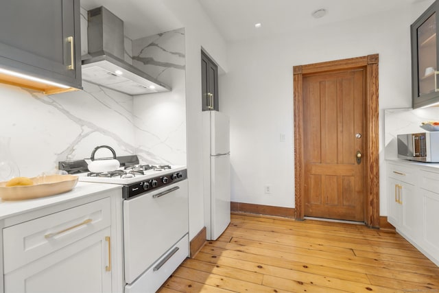 14 Jefferson St, Norwalk, CT 06851 - kitchen featuring white appliances, wall chimney range hood, decorative backsplash, light countertops, and light wood-style flooring