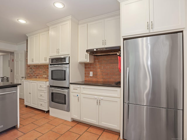 11 Dundee Rd, Stamford, CT 06903 - kitchen with appliances with stainless steel finishes, under cabinet range hood, tasteful backsplash, dark countertops, and white cabinetry