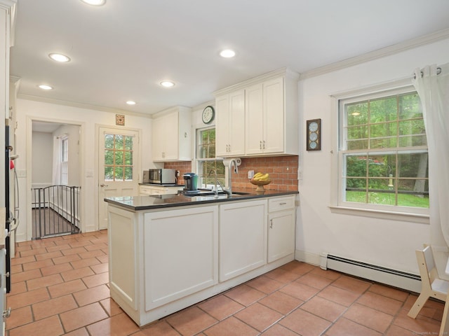 11 Dundee Rd, Stamford, CT 06903 - kitchen featuring baseboard heating, dark countertops, decorative backsplash, a peninsula, and ornamental molding