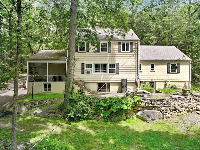 11 Dundee Rd, Stamford, CT 06903 - back of property featuring a patio, a chimney, a sunroom, and roof with shingles