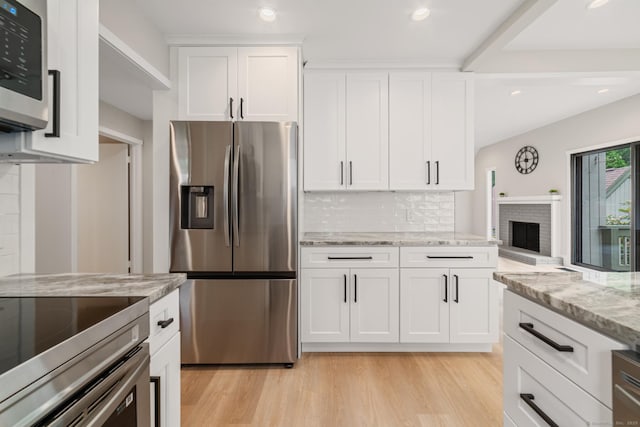 900 Heritage Vlg Unit B, Southbury, CT 06488 - kitchen featuring stainless steel appliances, decorative backsplash, light wood-style flooring, white cabinets, and light stone countertops