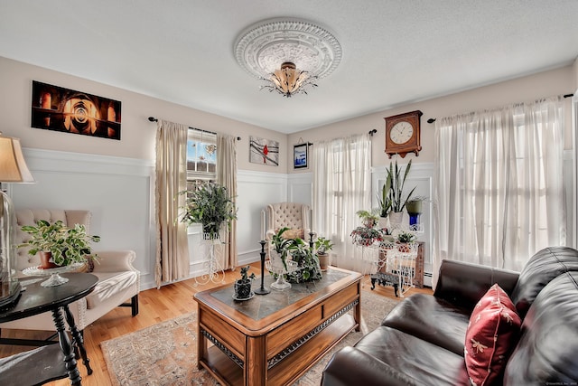 9 Anton Ln, Berlin, CT 06037 - living room with wainscoting, light wood-style flooring, and a decorative wall
