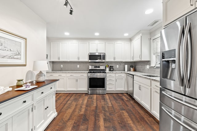 306 Hadley Dr Unit 306, Trumbull, CT 06611 - kitchen featuring stainless steel appliances, white cabinetry, decorative backsplash, light stone counters, and dark wood-type flooring