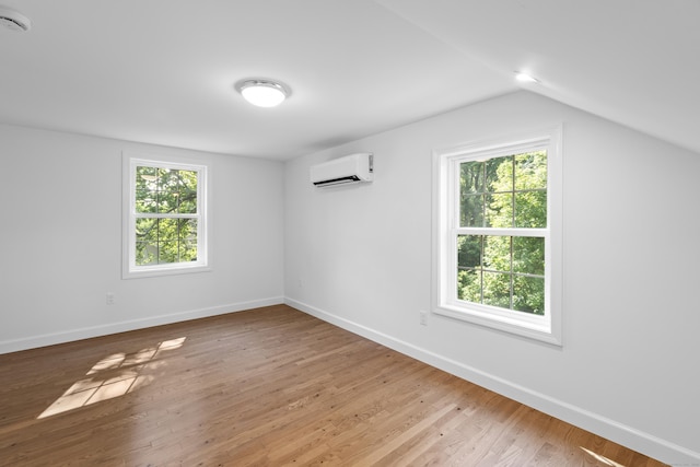 13 Brushy Plain Rd, Branford, CT 06405 - empty room featuring a wall mounted AC, vaulted ceiling, light wood-type flooring, and a smoke detector