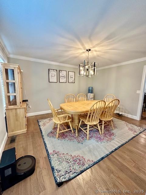 7 Pimlico Rd, Wolcott, CT 06716 - dining space featuring a chandelier, wood finished floors, and crown molding