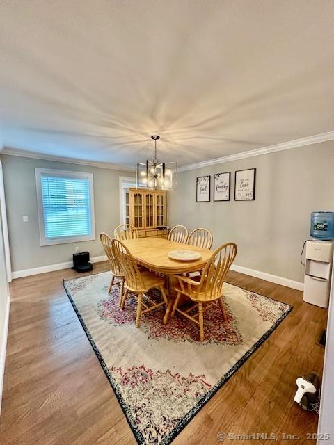 7 Pimlico Rd, Wolcott, CT 06716 - dining area featuring a chandelier, wood finished floors, and ornamental molding
