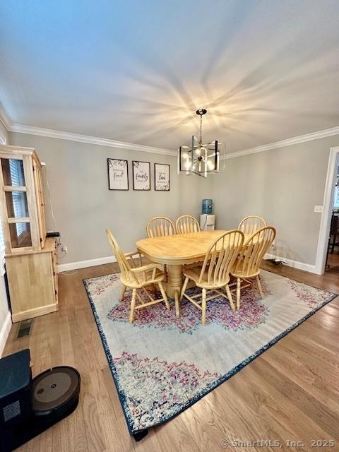 7 Pimlico Rd, Wolcott, CT 06716 - dining area with a chandelier, ornamental molding, and wood finished floors