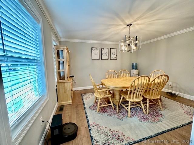 7 Pimlico Rd, Wolcott, CT 06716 - dining space featuring a chandelier, wood finished floors, and crown molding