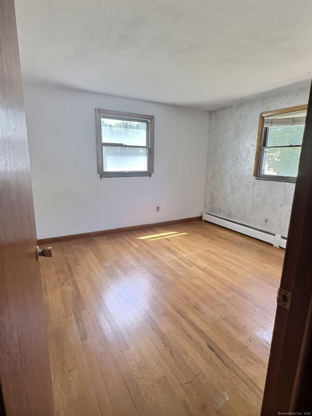 23 Westerly Dr, Enfield, CT 06082 - unfurnished room featuring a baseboard heating unit and wood finished floors