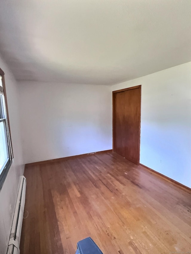 23 Westerly Dr, Enfield, CT 06082 - unfurnished room with a baseboard heating unit and wood finished floors