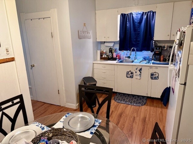 72 Stewart St, Bristol, CT 06010 - kitchen with freestanding refrigerator, light wood finished floors, white cabinets, and light countertops