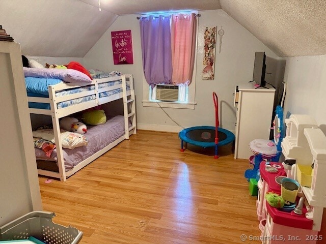 72 Stewart St, Bristol, CT 06010 - bedroom featuring wood finished floors, lofted ceiling, cooling unit, and a textured ceiling