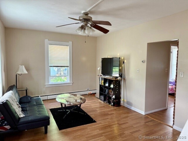 72 Stewart St, Bristol, CT 06010 - living area featuring wood finished floors, a baseboard heating unit, and ceiling fan
