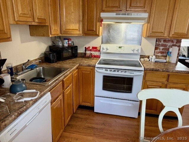 72 Stewart St, Bristol, CT 06010 - kitchen featuring under cabinet range hood, white appliances, light wood finished floors, and brown cabinetry