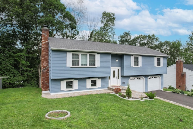 90 Haddad Rd, Waterbury, CT 06708 - bi-level home featuring a chimney, an attached garage, driveway, and a front lawn