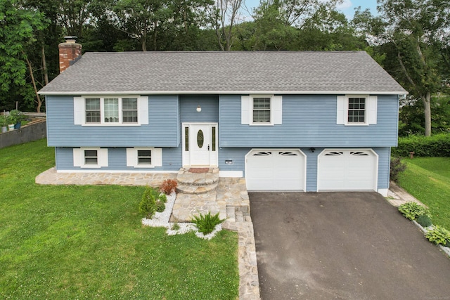 90 Haddad Rd, Waterbury, CT 06708 - split foyer home with an attached garage, a chimney, asphalt driveway, and a front lawn