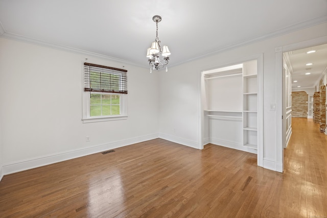 90 Haddad Rd, Waterbury, CT 06708 - unfurnished dining area featuring wood finished floors, a chandelier, crown molding, and built in features