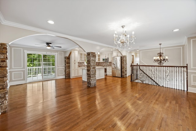 90 Haddad Rd, Waterbury, CT 06708 - unfurnished living room with arched walkways, a chandelier, decorative columns, a ceiling fan, and wood finished floors