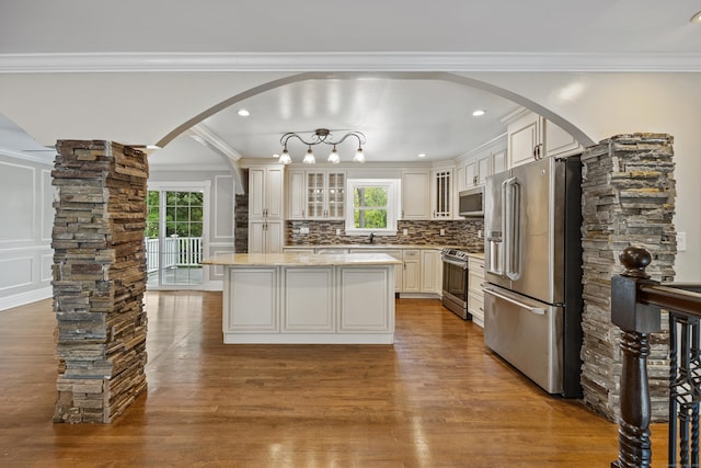 90 Haddad Rd, Waterbury, CT 06708 - kitchen with stainless steel appliances, arched walkways, wood finished floors, a center island, and plenty of natural light