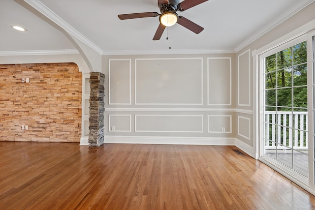 90 Haddad Rd, Waterbury, CT 06708 - spare room with arched walkways, ornate columns, wood finished floors, ornamental molding, and a decorative wall