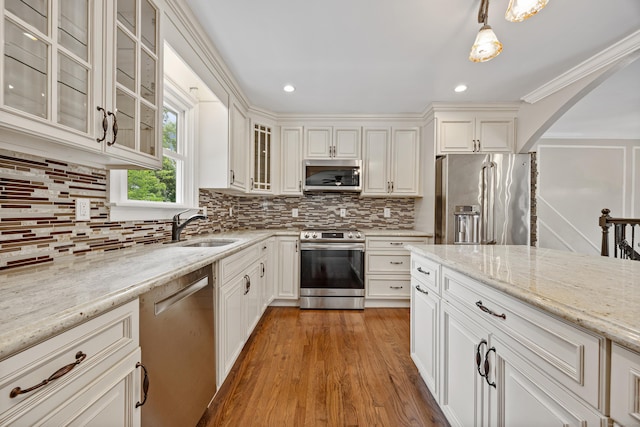 90 Haddad Rd, Waterbury, CT 06708 - kitchen with appliances with stainless steel finishes, arched walkways, light stone countertops, backsplash, and recessed lighting