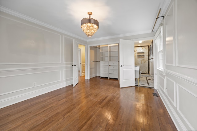 90 Haddad Rd, Waterbury, CT 06708 - unfurnished bedroom featuring a decorative wall, a chandelier, wood finished floors, and ornamental molding