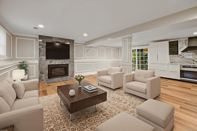 90 Haddad Rd, Waterbury, CT 06708 - living area with a decorative wall, decorative columns, light wood finished floors, recessed lighting, and a premium fireplace