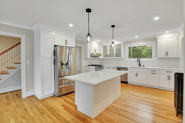 502 Adams St, Manchester, CT 06040 - kitchen with stainless steel appliances, backsplash, light wood-style flooring, white cabinets, and ornamental molding