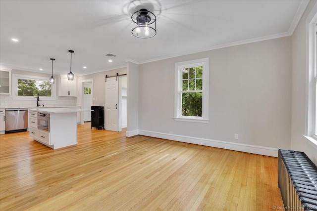 502 Adams St, Manchester, CT 06040 - kitchen with radiator, stainless steel appliances, a barn door, light countertops, and decorative backsplash