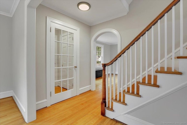 502 Adams St, Manchester, CT 06040 - entrance foyer with wood finished floors, crown molding, arched walkways, stairs, and radiator heating unit