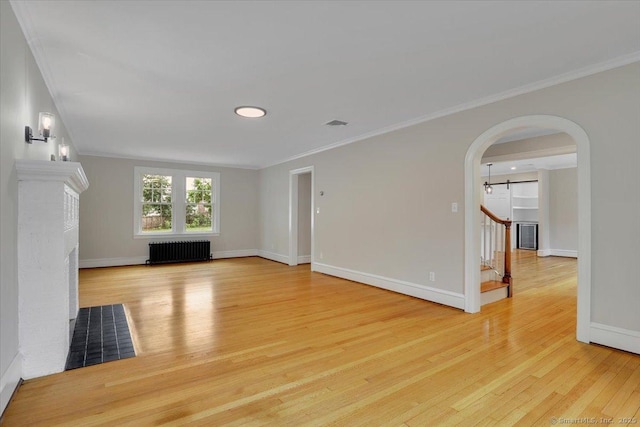 502 Adams St, Manchester, CT 06040 - unfurnished living room with radiator, light wood finished floors, stairs, arched walkways, and ornamental molding