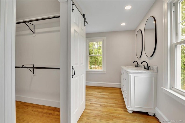 502 Adams St, Manchester, CT 06040 - bathroom with vanity, a walk in closet, healthy amount of natural light, wood finished floors, and recessed lighting