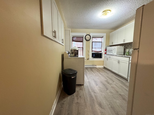 1485 Corbin Ave, New Britain, CT 06053 - kitchen featuring white appliances, light wood-style flooring, a baseboard heating unit, white cabinetry, and a textured ceiling