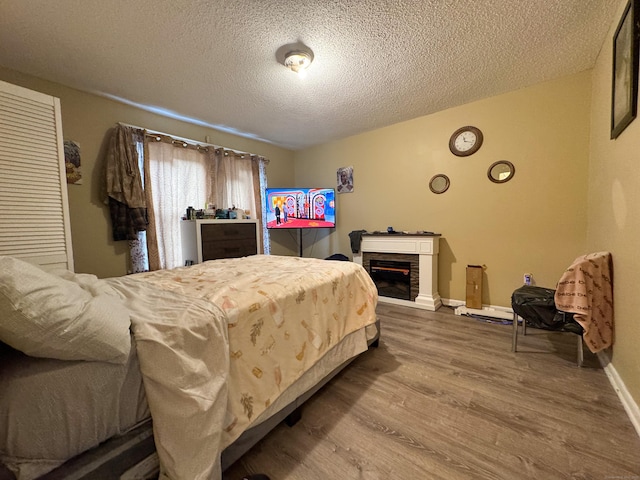 1485 Corbin Ave, New Britain, CT 06053 - bedroom featuring wood finished floors, a textured ceiling, and a fireplace