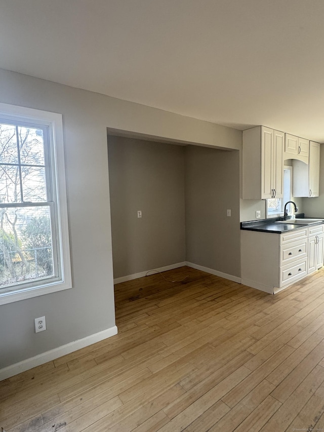 28 Devon Dr, Manchester, CT 06040 - kitchen featuring light wood finished floors, plenty of natural light, dark countertops, and white cabinetry